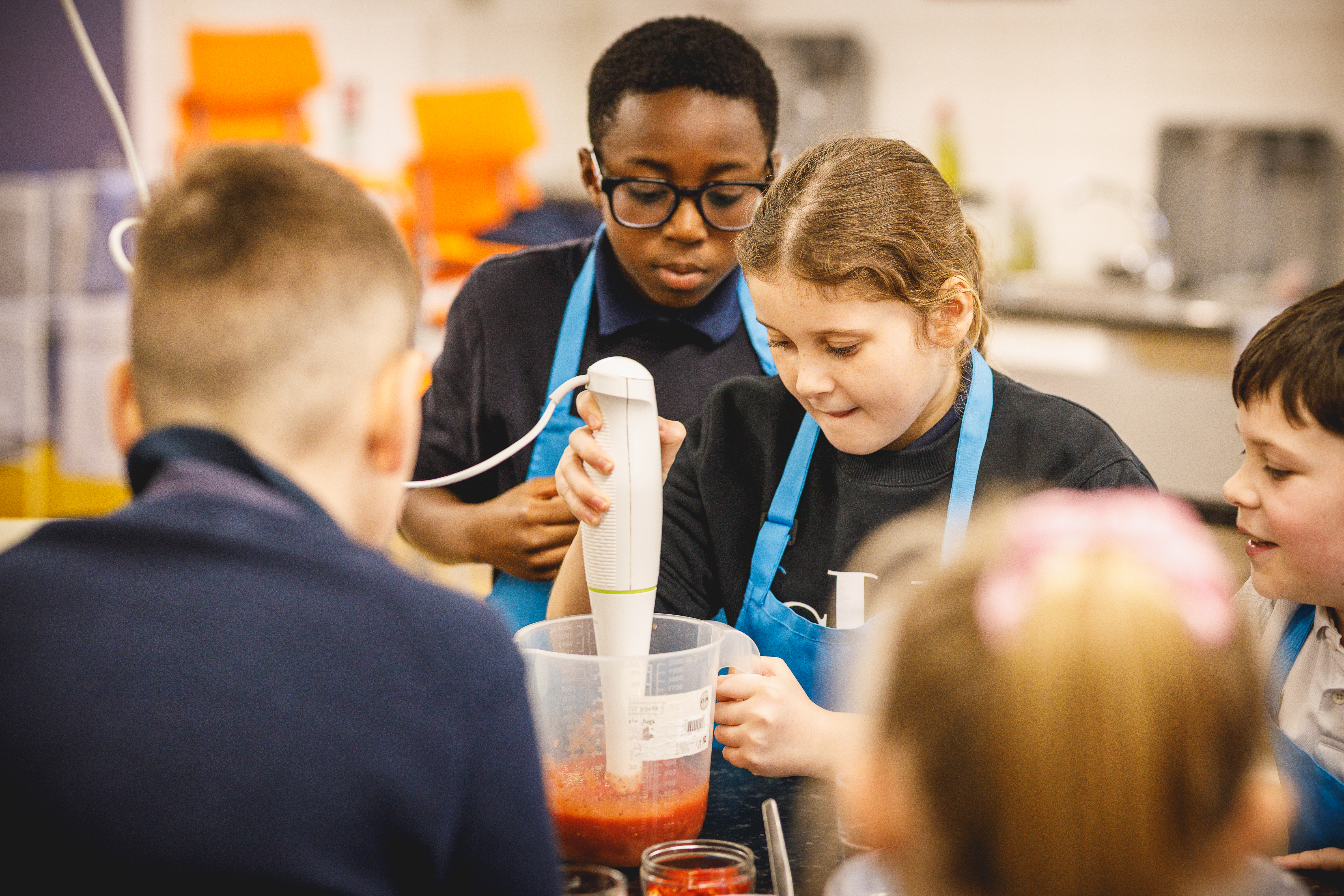 children looking into bowl with blender.jpg